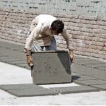 Labourer is busy spreading cement tiles for drying purposes after preparing at his workplace