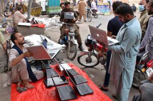 A street vender displaying used laptops to attract the customers at his road side setup