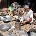 An artisan preparing iron tools at his workplace.