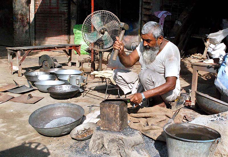 An artisan preparing iron tools at his workplace.