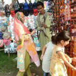 Vendor displaying Sunglasses to attract customers while shuttling on the road.