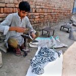A blacksmith sits by the roadside making Payal and Jhanjhariya for animals