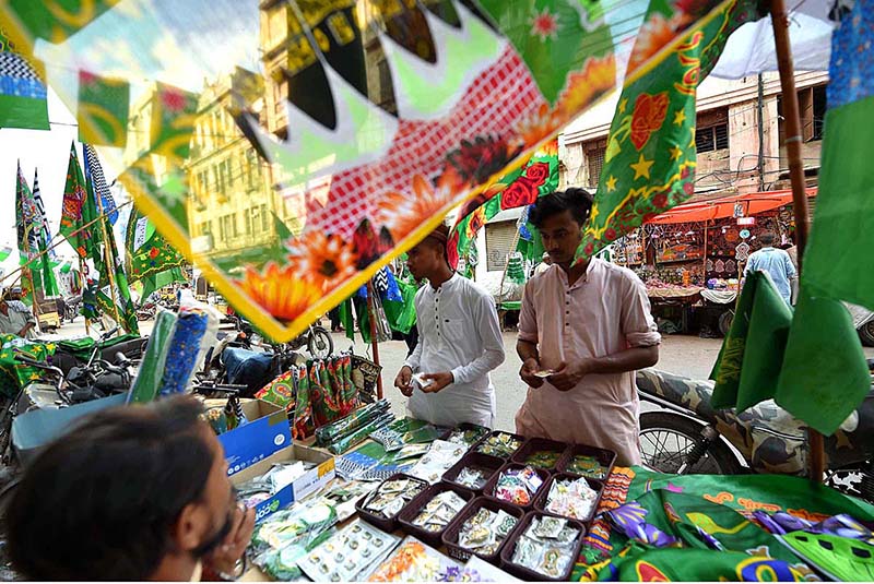Buntings, flags, badges and souvenirs are displayed at the roadside stalls in connection with 12th Rabi-ul-Awwal at Paper Market