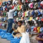 Customers selecting and purchasing caps from a roadside vendor