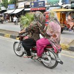 Women are now comfortable to use motorcycle for travel in the city.