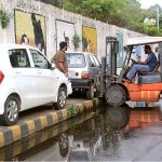 Traffic police warden removing wrong parked vehicle on footpath