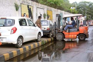 Traffic police warden removing wrong parked vehicle on footpath