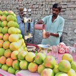 A vendor extracting juice for customers at Railway Station Road.