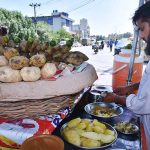 A vendor selling food Item Shakar Khandi at his road side setup