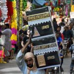 A man carrying the decorated Makkah sculpture at Urdu Bazar in connection with Eid-e-Milad-un-Nabi (SAWW) celebrations