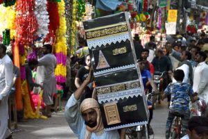 A man carrying the decorated Makkah sculpture at Urdu Bazar in connection with Eid-e-Milad-un-Nabi (SAWW) celebrations