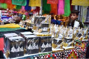 A young vendor displaying the Holly Kaaba model and different kind of decoration stuff at Urdu Bazar in connection with Eid-e-Milad-un-Nabi (SAWW) celebrations.