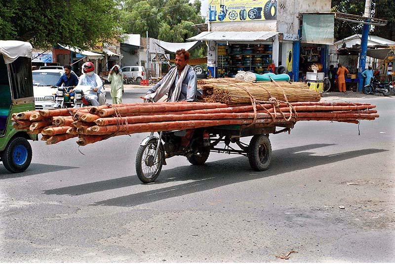Bamboo loading tricycle rickshaw heading towards on its way