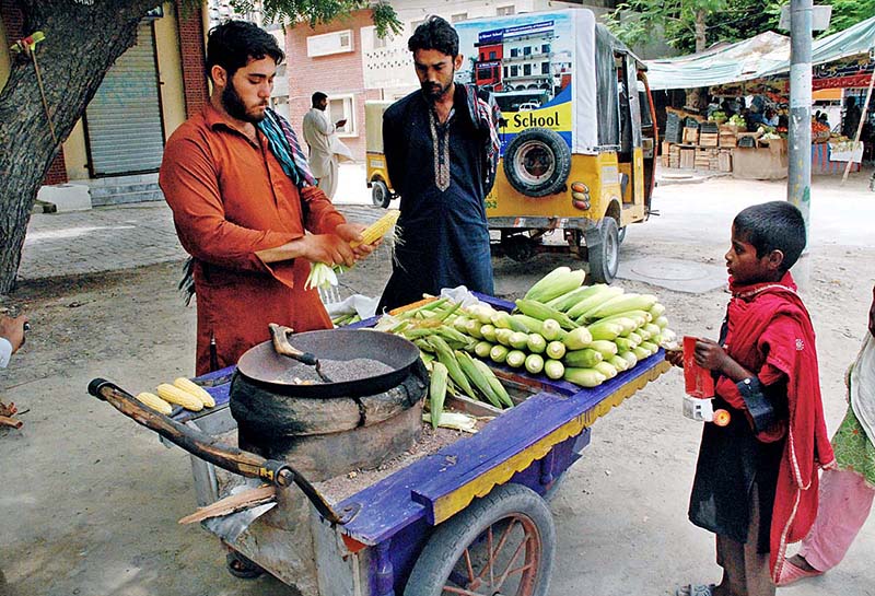 Daily wager preparing popcorn for customers on roadside in the city