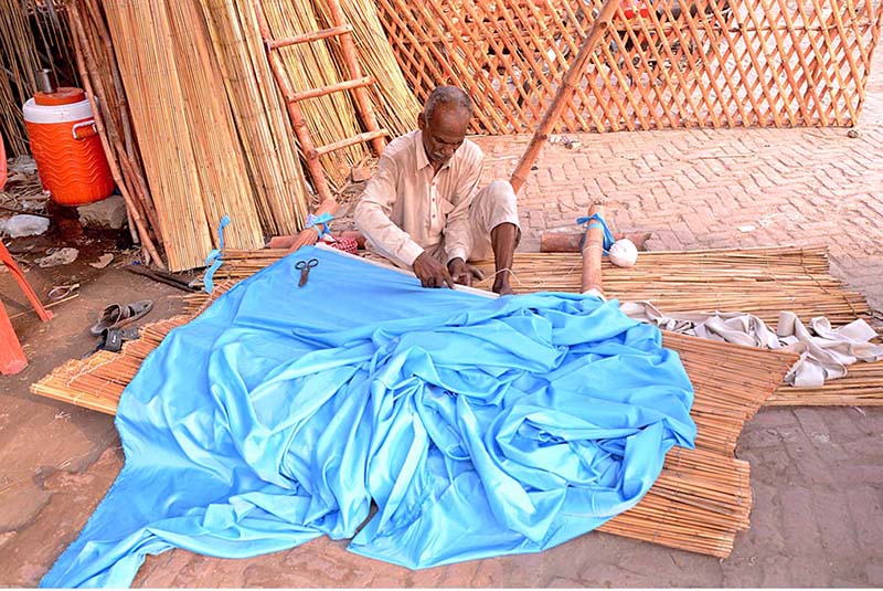 A worker preparing traditional reed curtain (chick) at his workplace
