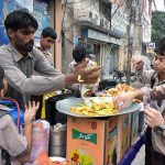 Students purchasing food items from roadside vendor