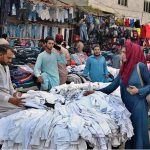 Woman selecting and purchasing old clothes at Landa Bazaar