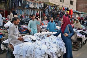 Woman selecting and purchasing old clothes at Landa Bazaar