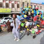 A worker supplying kids cycles to shops at Shahra-e-Iqbal