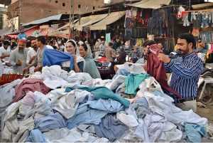 Woman selecting and purchasing old clothes at Landa Bazaar