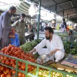 People purchasing fresh vegetables from a stall in H-9 weekly bazar.