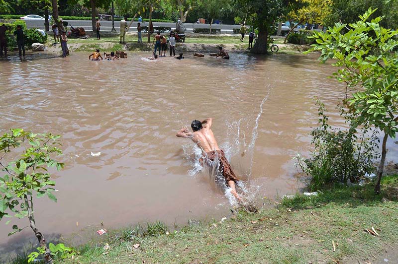 Children are taking a dip in the canal to alleviate the sweltering heat