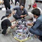 Youngsters selecting sun glasses from a vendor at H-9 weekly bazar