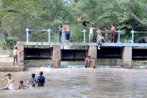 Children are taking a dip in the canal to alleviate the sweltering heat