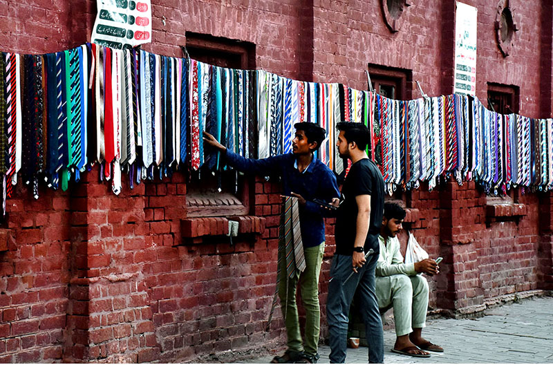 A vendor displaying and selling the dress ties to the customers on the wall of Haji camp at Landa bazar in the Provincial Capital