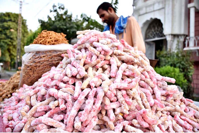 A vendor arranging and displaying the traditional sweet candy to the customers on their handcart at roadside setup.