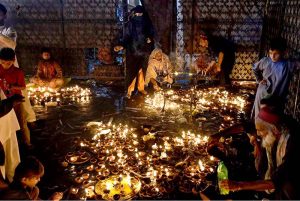 A devotee lits-up earth lamps at Data Darbar in connection with 980th Urs celebrations of Data Ali Hajveri as a large number of people arrive to attend the three-day Urs celebrations