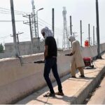 Labourers are busy installing protection wire on the wall of Naag Shah Flyover