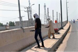 Labourers are busy installing protection wire on the wall of Naag Shah Flyover