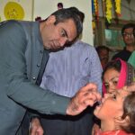 Deputy Commissioner Capt (Retd) Shoaib Ali administering polio drops to a child at DHQ Teaching Hospital Sargodha.