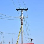WAPDA staffers busy in installing new electric wires on electric poles at Taramri Chowk.