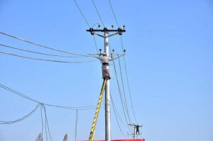 WAPDA staffers busy in installing new electric wires on electric poles at Taramri Chowk.