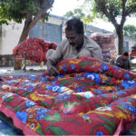 Worker busy in stitching cozy quilts for upcoming winter season at their workplace as the demand of warm goods increased after the temperature dropping rapidly in the city