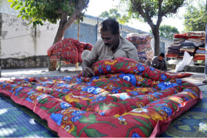 Worker busy in stitching cozy quilts for upcoming winter season at their workplace as the demand of warm goods increased after the temperature dropping rapidly in the city