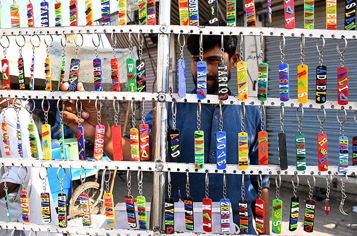 A vendor displaying and selling key rings at Jinnah Bagh Chowk.