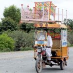 A view of motorcycle rickshaw on the way loaded stuff on rooftop at Naranwala Road.
