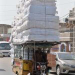 A tricycle rickshaw on the way overloaded with luggage
