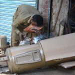 A worker busy in making geyser at his shop as its demand increased during winter season