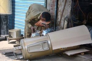 A worker busy in making geyser at his shop as its demand increased during winter season