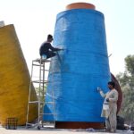 PHA workers busy in paint a model of textile yarn in GTS Chowk.