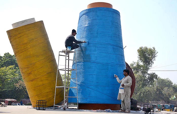 PHA workers busy in paint a model of textile yarn in GTS Chowk.