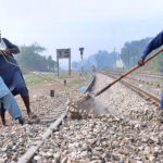 Railway workers are busy laying stones around the railway tracks during maintenance work near Timber Market