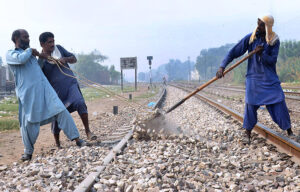 Railway workers are busy laying stones around the railway tracks during maintenance work near Timber Market