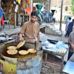 A worker busy in preparing the traditional food item ‘paratas’ for the customer at local hotel