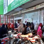 A large number of women standing in a queue waiting their turn outside Utility Store to purchase grocery items at Rasheedabad.