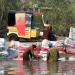 Laborers washing empty plastic bags in the canal
